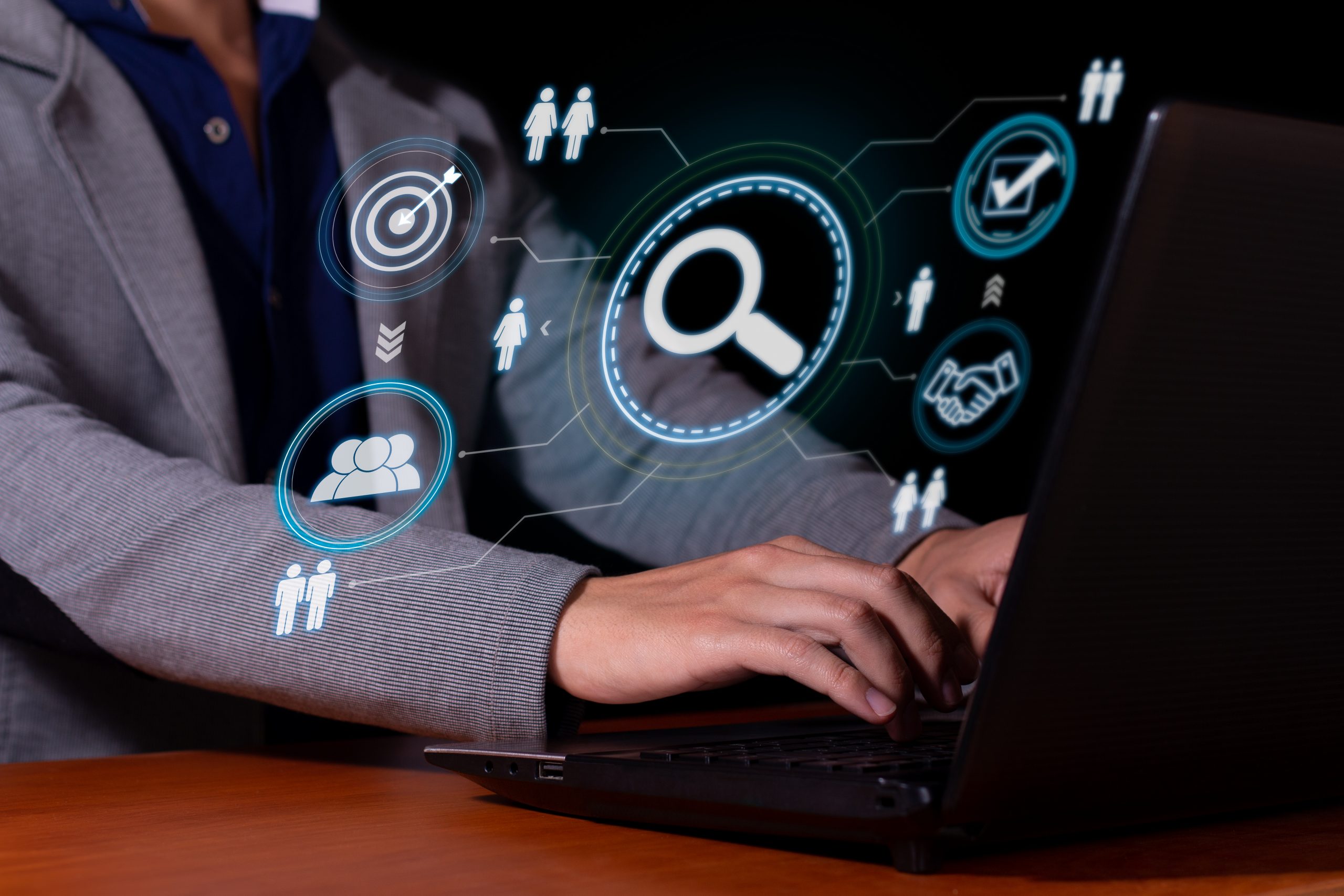 Person in einem Anzug sitzt an einem Laptop und es gibt visuelle bilder